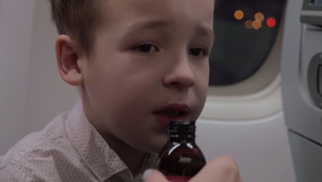 Kid-in-plane-taking-medicine