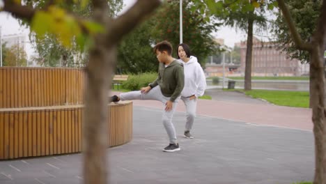 Mujer-asiática-y-su-hijo-haciendo-ejercicio-al-aire-libre-en-la-calle-peatonal-urbana