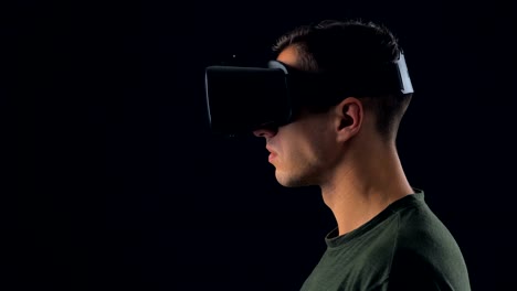 Portrait-of-Young-Man-using-VR-Glasses-on-Black-Background.-Male-Virtual-Reality-Console-Headset-Play-3D-Gaming-Innovation-Internet-Entertainment-Technology