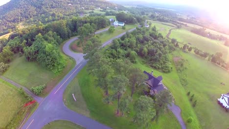 aerial-fly-over-homes-and-church-with-sun-flare