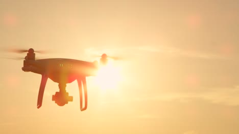 CERRAR-destello-de-lente-de-cámara-lenta:-Pequeña-filmación-drone-volando-en-el-cielo-al-atardecer-dorado