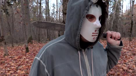 Beängstigend-Charakter-in-scary-Halloweenmaske-und-Machete-im-park