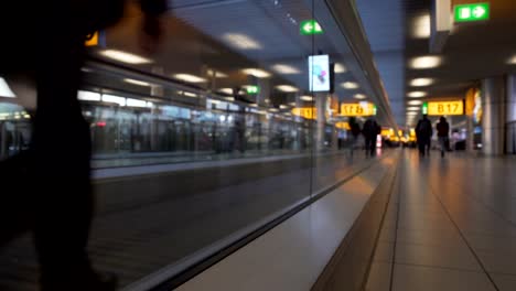 Women-and-men-with-bags-moving-on-escalator-at-airport-terminal,-bottom-view