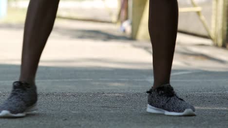 Hombre-africano-en-zapatillas-jugando-baloncesto-en-el-patio-exterior,-practicando