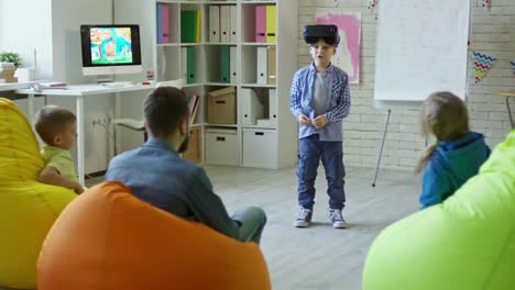 Kleiner-Junge-in-VR-Kopfhörer-rezitieren-eine-Lektion-in-der-Grundschule