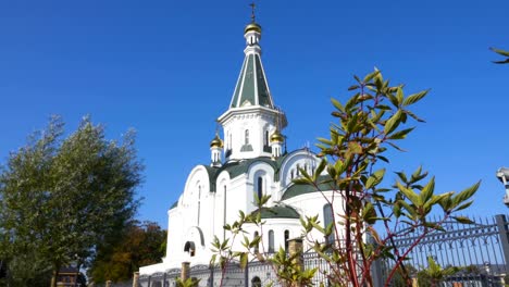 Dome-of-the-Church-and-leaves.-The-silhouette-of-the-cross-and-church-bell-tower-in-sunrise.-An-autumn-windy-day-shakes-the-leaves-of-the-trees.