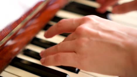 Mujeres-de-los-dedos-tocando-las-teclas-en-teclado-piano-retro.-Profundidad-de-campo.-Centrarse-en-las-manos