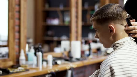 Professional-barber-makes-modern-hairstyle-for-young-caucasian-guy