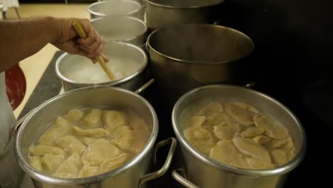 Cafeteria-Cook-rührt-kochende-Töpfe-auf-Herd