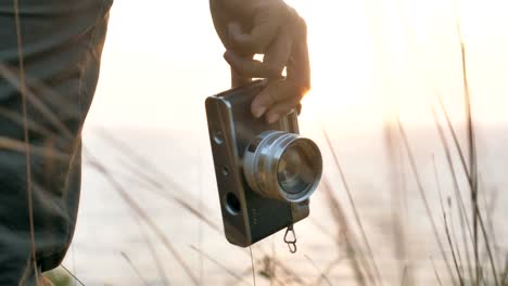 An-individual-holding-a-vintage-or-film-camera-in-the-hand