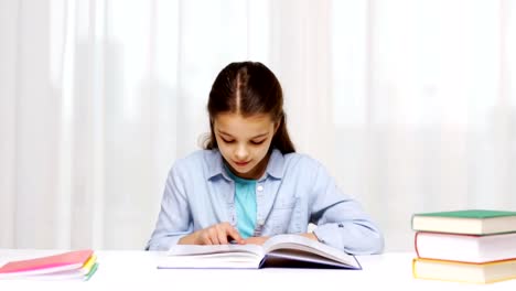 happy-school-girl-reading-book-or-textbook-at-home