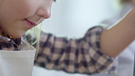 Smiling-Girl-Grating-Cheese-in-Kitchen