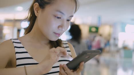 Woman-using-mobile-phone-in-the-mall