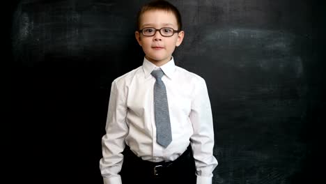 Young-boy-standing-in-a-bossy-pose,-looking-straight-to-camera.-Creative-concept-of-back-to-school-and-study.-Pre-school