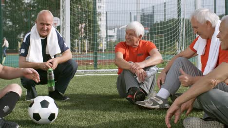 Personas-mayores,-relajarse-y-hablar-después-de-jugar-al-fútbol