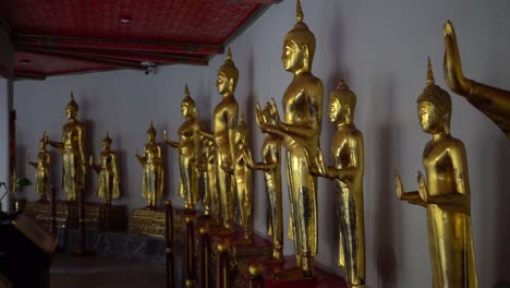 Oro-las-estatuas-de-Buda-en-la-fila-en-el-Wat-Pho,-la-ciudad-de-Bangkok,-Tailandia