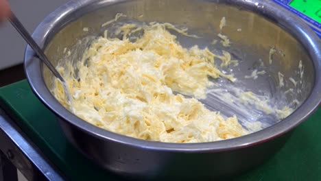 A-man's-hand-stirring-white-sauce.-The-chef-prepares-the-sauce-and-cheese.-Food.-Kitchen.-healthy-diet.-Close-up.-HD