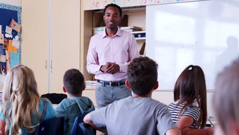 Male-teacher-talks-to-pupils-in-lesson-at-elementary-school