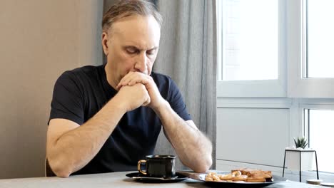 Adult-man-in-the-morning-in-the-kitchen,-thinking-about-their-problems.-He-is-drinking-coffee