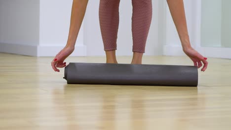 young-woman-feet-unrolling-mat-and-sitting-on-it-in-slow-motion