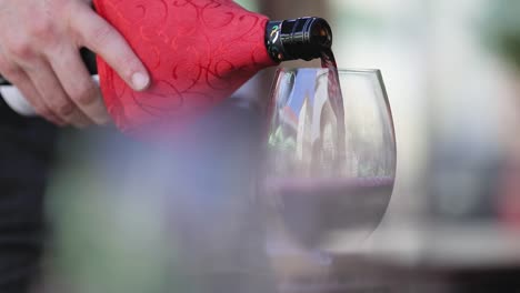 Red-Wine.-Waiter-Pouring-Wine-In-Glass-At-Restaurant-Closeup