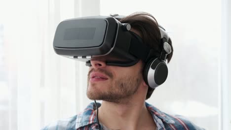 Young-man-using-his-virtual-reality-glasses