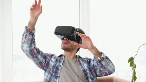 Man-wearing-vr-headset-and-gesturing-on-sofa