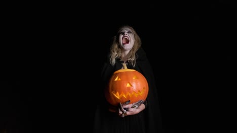 Halloween-Image-.Young-Witch-In-Black-Clothes-Holds-Pumpkin-In-Her-Hands.