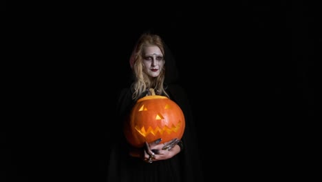 Halloween-Image-.Young-Witch-In-Black-Clothes-Holds-Pumpkin-In-Her-Hands.