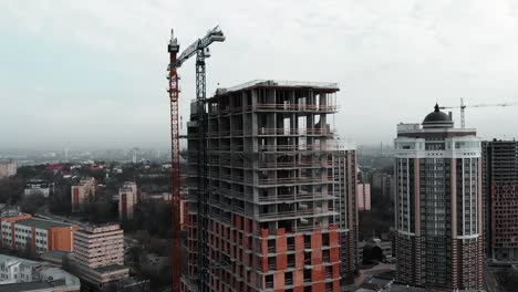 Unfinished-residential-complex-in-city-center.-Construction-crane-near-development-building.-Construction-works-in-metropolis