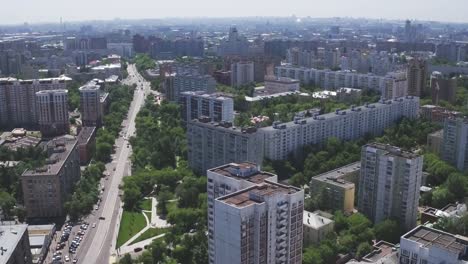 Vista-aérea-panorámica-de-uno-de-los-distritos-de-Moscú-con-edificios-residenciales,-parques-infantiles,-jardín-de-infantes-y-tráfico-por-carretera,-clima-de-verano.-Paisaje-urbano-de-quadrocopter