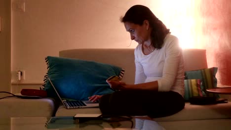 Woman-in-front-of-the-computer-at-her-living-room.-Woman-in-her-30s-checking-and-surfing-the-internet