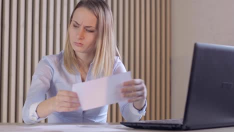 Depressed-woman-checking-her-expenses-in-her-living-room