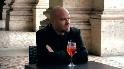 Sad-and-thoughtful-man-sitting-at-the-table-with-drink