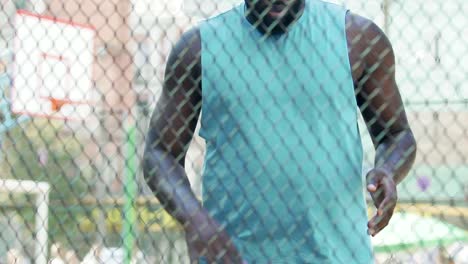 African-american-guy-handling-ball-warming-up-muscles-before-basketball-training