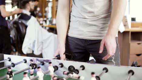 Hairdresser-makes-hairstyle-for-young-man-at-blurred-background-of-brush