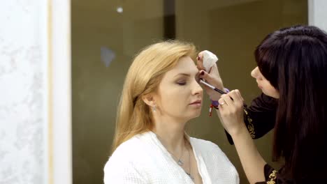 Esteticista-realiza-maquillaje-para-mujer-madura-en-salón-de-belleza