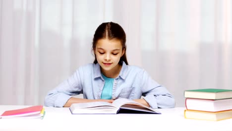 happy-school-girl-reading-book-or-textbook-at-home