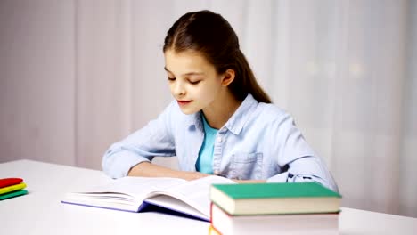 happy-school-girl-reading-book-or-textbook-at-home