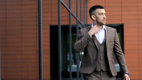 Businessman-Walking-on-Streets-of-Business-District-and-see-time