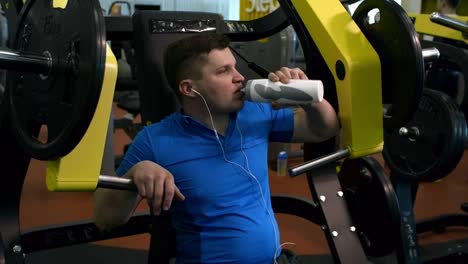 Man-Drinking-Water-and-Resting-in-Gym