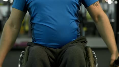 Hombre-determinado-en-el-ejercicio-de-la-silla-de-ruedas-en-la-máquina-del-Cable