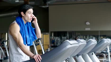 A-shirtless-guy-at-the-gym,-trains-his-body-to-stay-fit-and-have-defined-muscles.-The-athlete-raises-heavy-weights-and-fatigue.