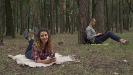 Hombre-joven-y-mujer-pasar-tiempo-en-el-parque-con-gadjets