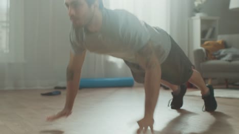 Slow-Motion-in-der-Nähe-von-einen-starken-Athletic-Fit-Mann-in-T-shirt-und-Shorts-tun-klatschte-Push-Up-Übungen-zu-Hause-in-seinem-geräumigen-und-hellen-Wohnzimmer-mit-minimalistisches-Interieur.