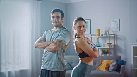 Muskulöser-sportlicher-Mann-und-schöne-Fitness-Frau-in-Trainingskleidung-sind-vertraulich-posiert-in-ihre-helle-und-geräumige-Wohnung-mit-minimalistisches-Interieur.