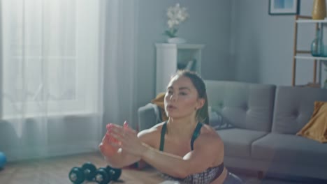 Close-Up-of-a-Fit-Beautiful-Athletic-Girl-in-Workout-Clothes-Doing-Squat-Exercises-in-Her-Bright-and-Spacious-Living-Room-with-Minimalistic-Interior.