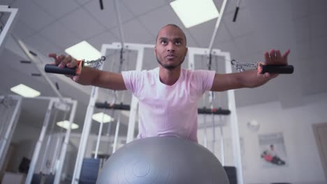 African-American-guy-doing-exercise-on-the-simulator-lying-on-therapy-ball.-Pediatric-Physical-Therapy