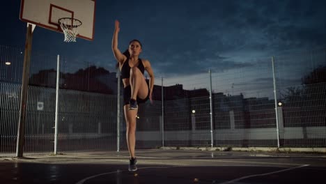 Adecuación-energética-hermosa-chica-haciendo-ejercicios.-Ella-está-haciendo-un-entrenamiento-en-una-cancha-de-baloncesto-al-aire-libre-cercado.-Imágenes-de-noche-después-de-la-lluvia-en-una-zona-de-barrio-residencial.