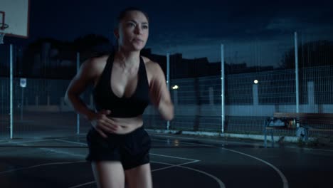 Cerca-de-una-chica-de-hermoso-aptitud-energética-haciendo-pies-corriendo-taladro.-Ella-está-haciendo-un-entrenamiento-en-una-cancha-de-baloncesto-al-aire-libre-cercado.-Imágenes-de-la-noche-después-de-la-lluvia-en-una-zona-residencial-del-barrio.